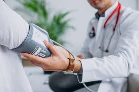  La imagen muestra a un médico realizando un procedimiento de toma de presión arterial a un paciente ambulatorio en la comodidad de su hogar. 